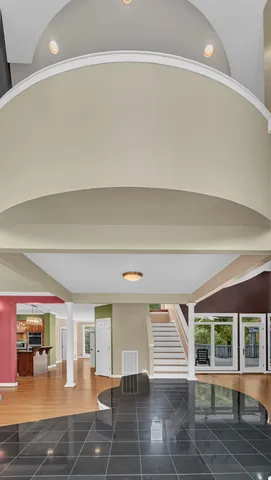 a view of a livingroom with a fireplace a chandelier wooden floor and staircase