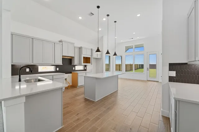 a large kitchen with stainless steel appliances and a white cabinets