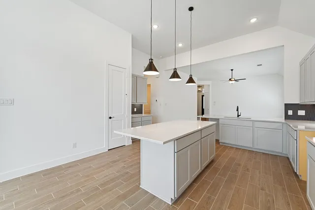 a kitchen with a sink stove and wooden floor