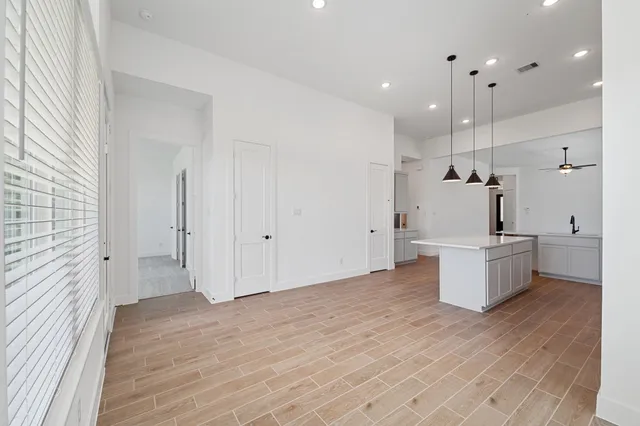 a view of a kitchen with white cabinets and stainless steel appliances