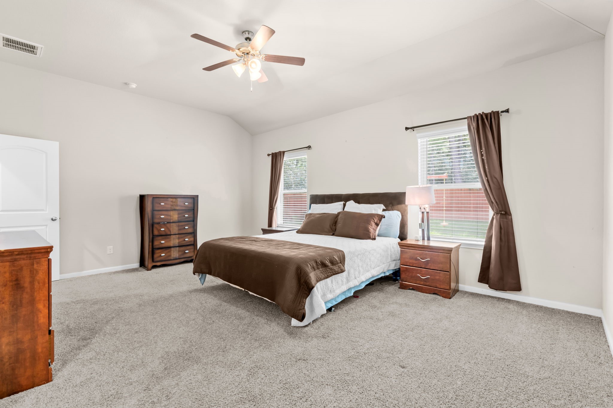 14388 Zion Gate Crossing Conroe, TX 77384 - Photo 13 of 34 a bedroom with a large bed and a chandelier