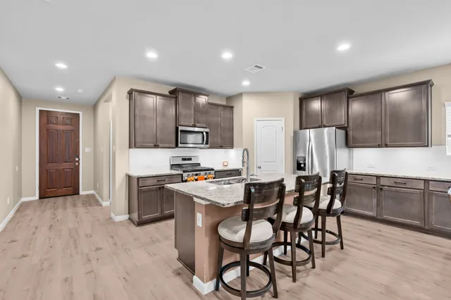 a kitchen with stainless steel appliances a refrigerator stove microwave and cabinets