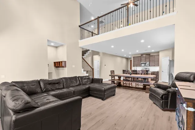 a living room with furniture kitchen view and a wooden floor