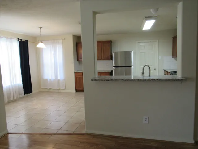 a view of kitchen with granite countertop cabinets and sink