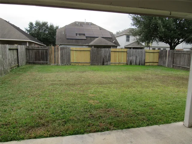 a view of a backyard with a garden and tree