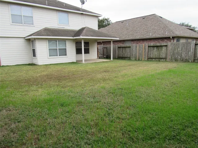 a view of a yard in front of a house with large tree