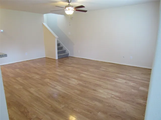 a view of an empty room with a chandelier fan