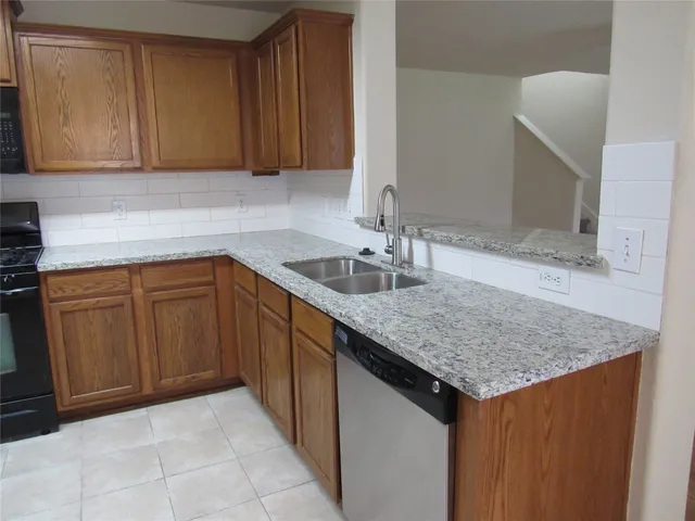 a kitchen with a sink dishwasher and cabinets
