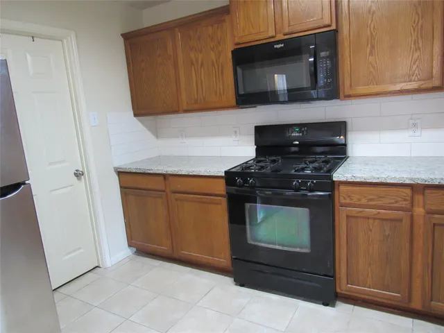 a kitchen with granite countertop white cabinets and stainless steel appliances