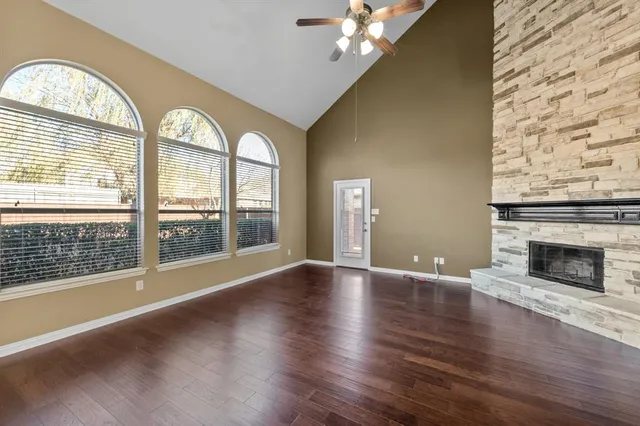 wooden floor fireplace and windows in an empty room