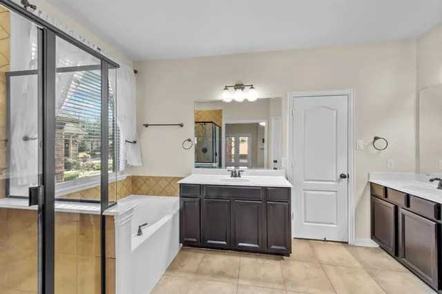 a spacious bathroom with a tub sink and mirror