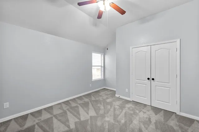 an empty room with chandelier fan