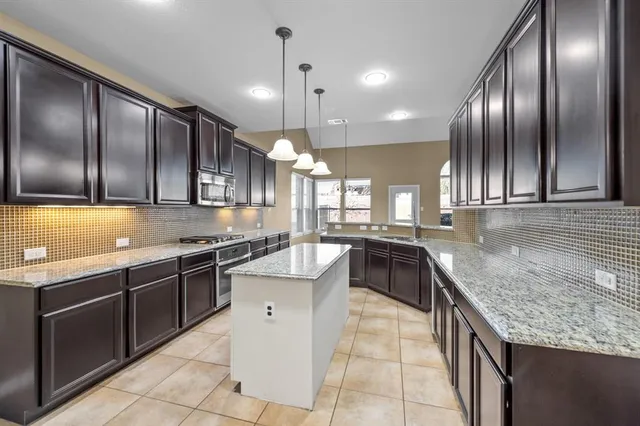 a kitchen with stainless steel appliances granite countertop a sink counter space cabinets and a large window