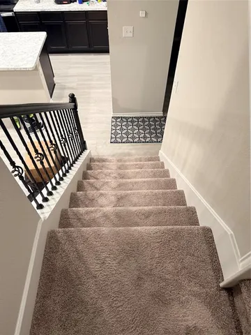 a view of staircase with wooden floor and white walls