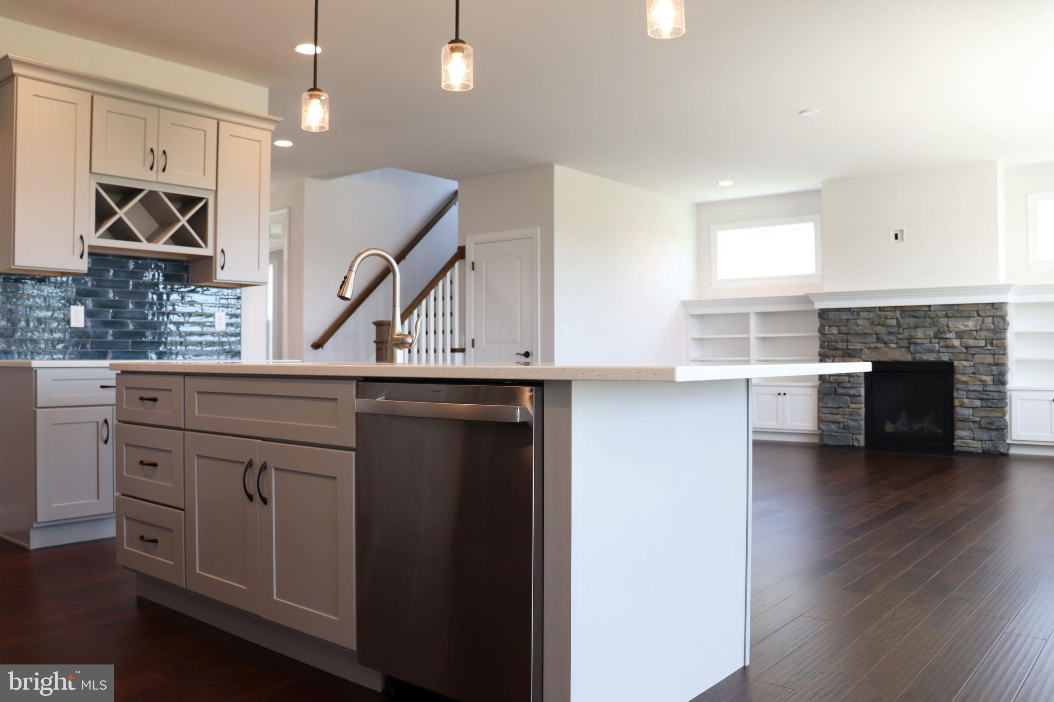 1029 Strafford Place, Unit 55 Lancaster, PA 17601 - Photo 12 of 40 a kitchen with a sink dishwasher a fireplace and a stove with wooden floor