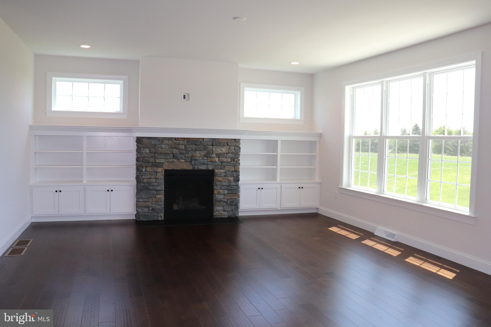 1029 Strafford Place, Unit 55 Lancaster, PA 17601 - Photo 6 of 40 an empty room with wooden floor fireplace and windows