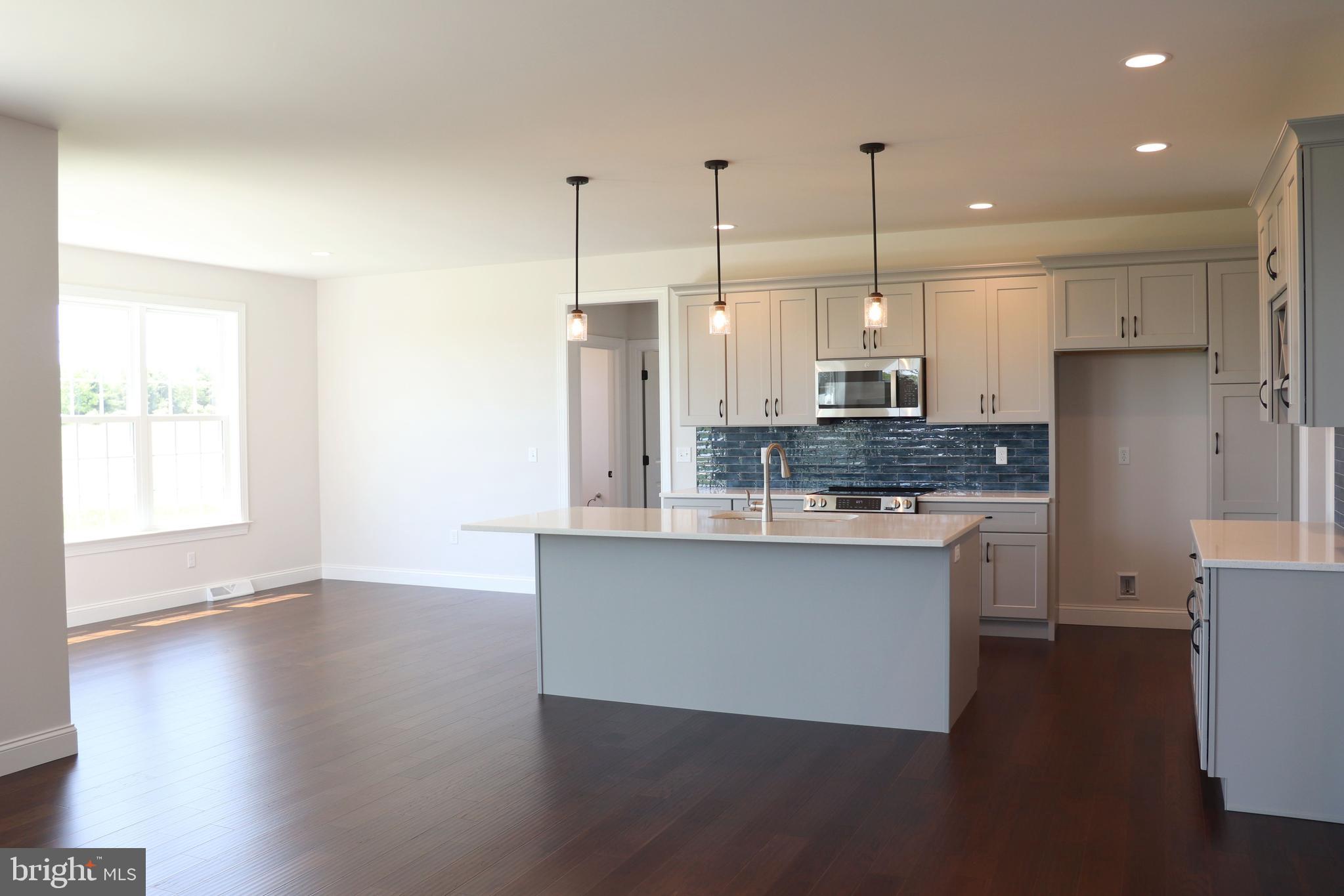 1029 Strafford Place, Unit 55 Lancaster, PA 17601 - Photo 8 of 40 a kitchen with stainless steel appliances granite countertop a sink a stove a refrigerator a center island and a window