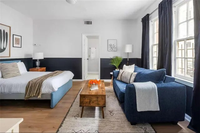 a bedroom with a bed and a lamp on dresser