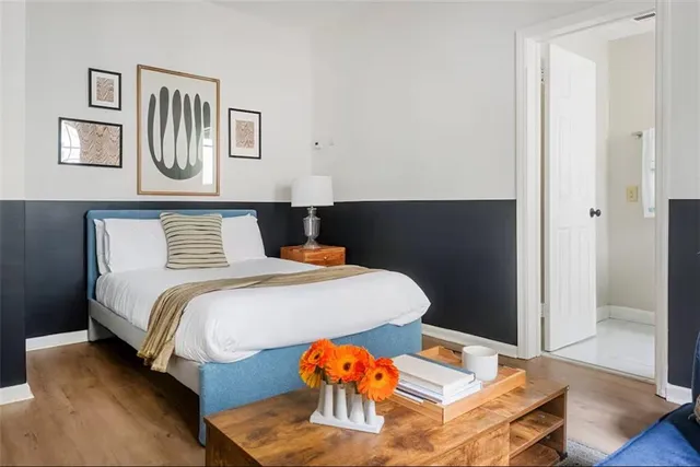 a bedroom with a bed and wooden floor