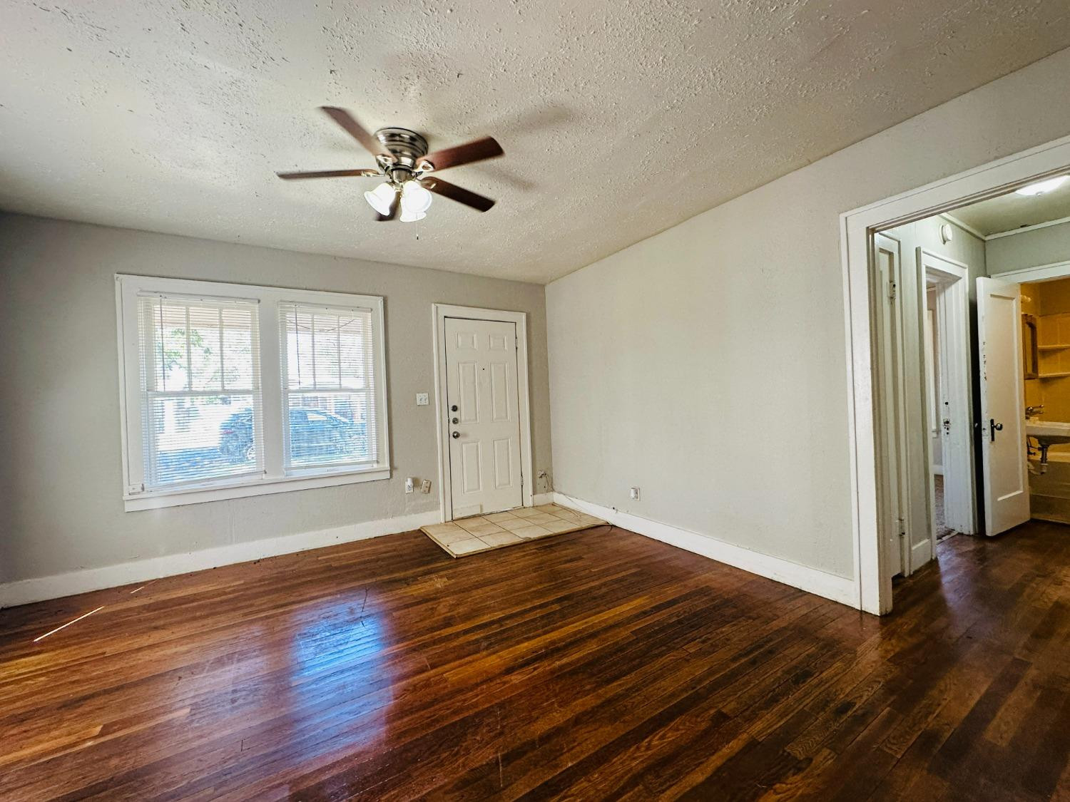 2117 15th Street, Unit A Lubbock, TX 79401 - Photo 2 of 11 a view of empty room with wooden floor and fan