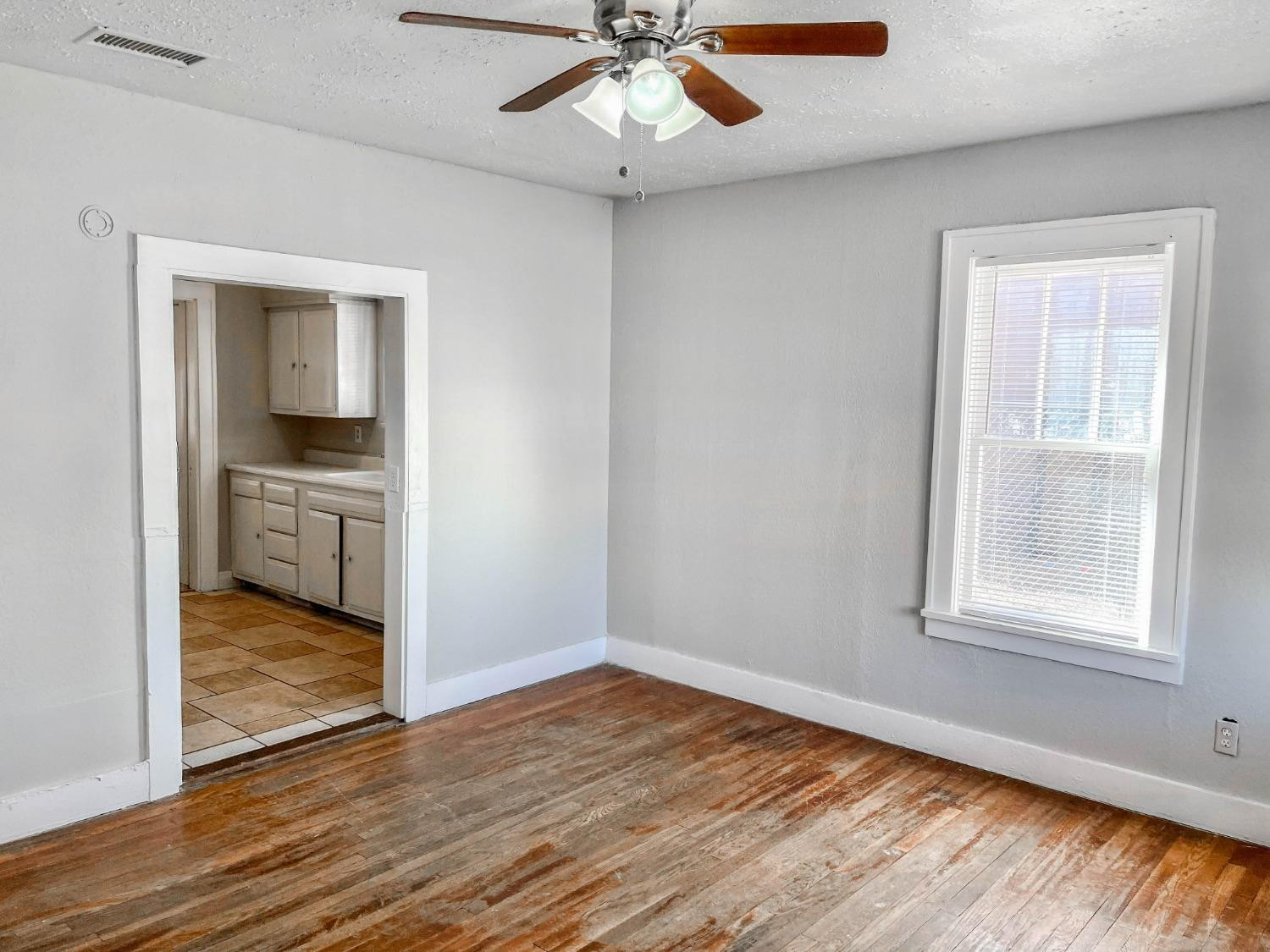2117 15th Street, Unit A Lubbock, TX 79401 - Photo 9 of 11 wooden floor in an empty room with a window