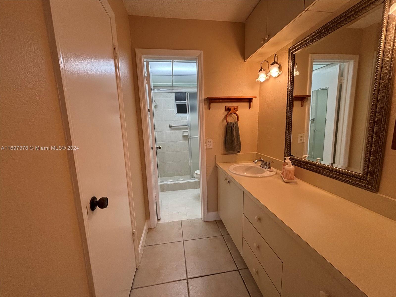 3181 Southwest 13th Street, Unit 111 Miami, FL 33145 - Photo 21 of 25 Vanity with bathroom in the back and walk-in closet door on the left.
