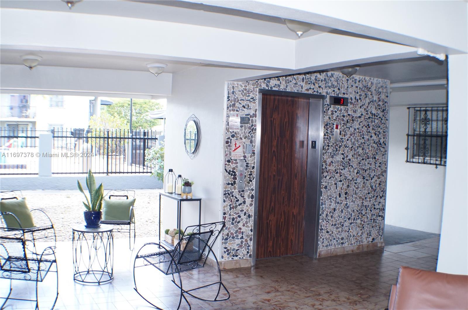 3181 Southwest 13th Street, Unit 111 Miami, FL 33145 - Photo 5 of 25 The lobby with the elevator on the right corner and the pool in the background