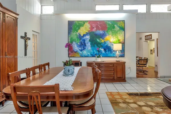 a view of a dining room with furniture one side kitchen view and wooden floor