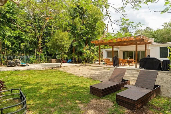 a view of a swimming pool with couches and lounge chairs