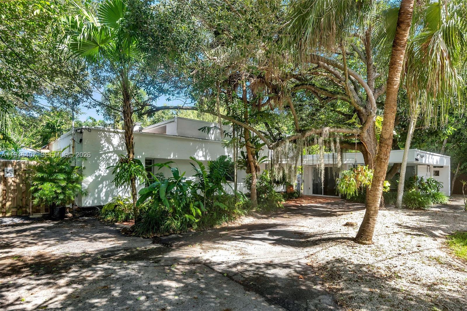 5845 Southwest 88th Street Miami, FL 33156 - Photo 5 of 25 a pathway of a house with a yard and large trees
