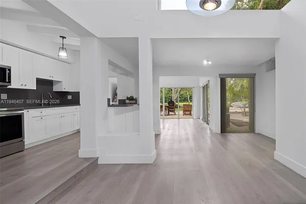 a view of a kitchen with a sink oven cabinets and wooden floor