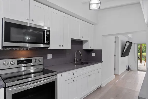a kitchen with stainless steel appliances a stove microwave and cabinets