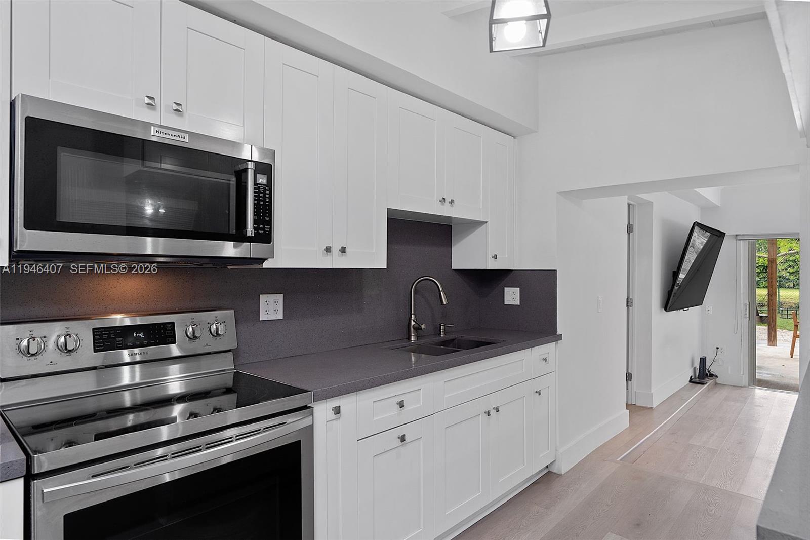 5845 Southwest 88th Street Miami, FL 33156 - Photo 10 of 25 a kitchen with stainless steel appliances a stove microwave and cabinets