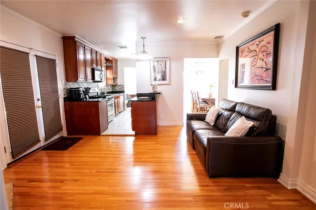 a living room with stainless steel appliances furniture or kitchen view and a refrigerator