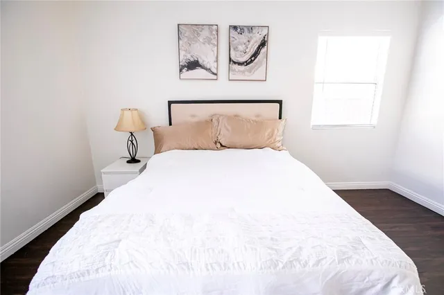 a large white bed in a bedroom next to a window