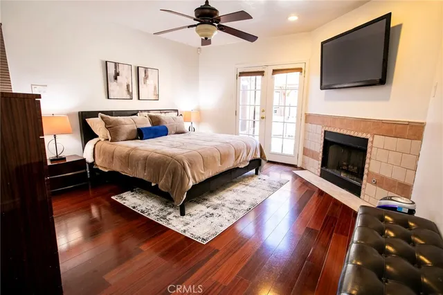 a spacious bedroom with a bed a flat screen tv and a fireplace