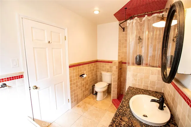 a bathroom with a toilet a sink and mirror