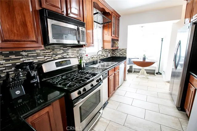 a kitchen with stainless steel appliances a stove microwave and sink