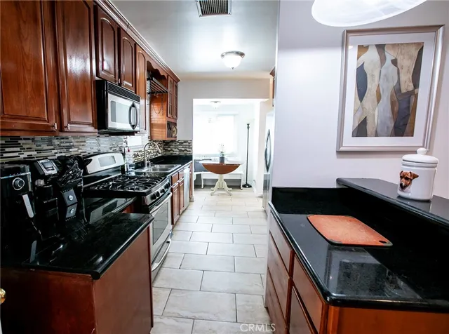 a kitchen with a sink a stove and cabinets