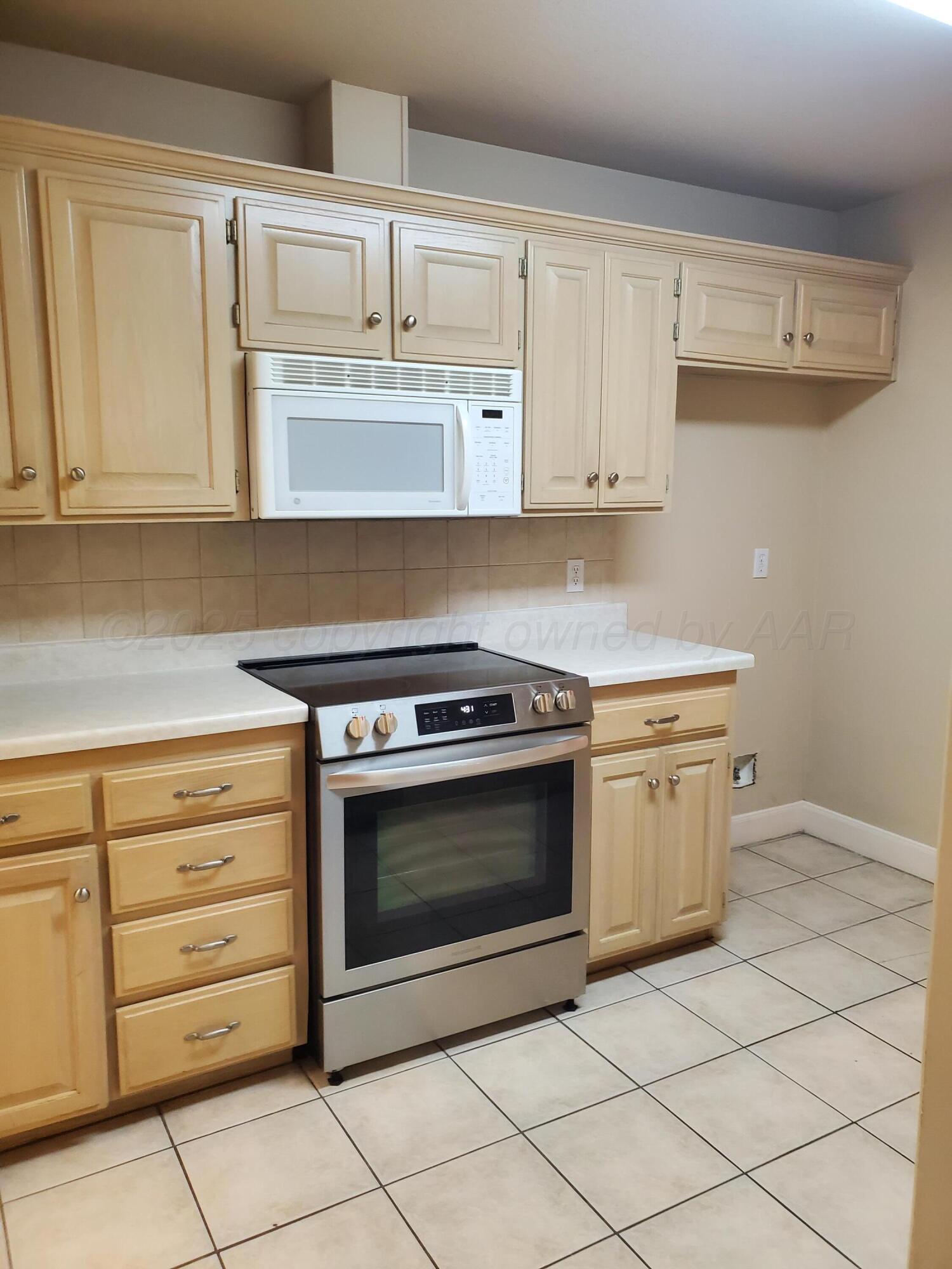 1 Windtree Amarillo, TX 79109 - Photo 15 of 18 a kitchen with white cabinets and appliances