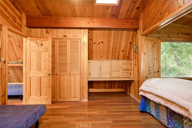 a view of a hallway with wooden floor and a bathroom