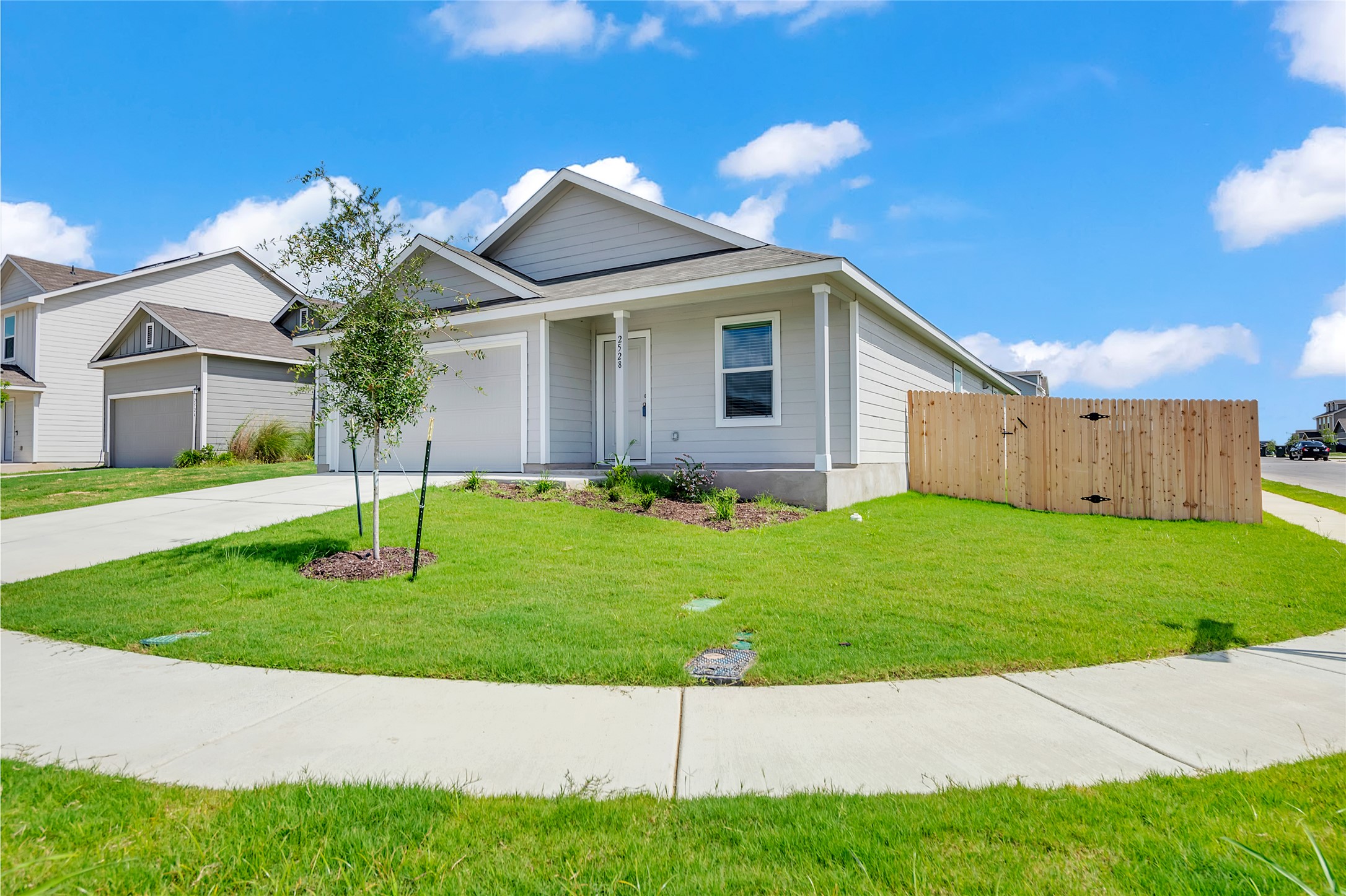 2528 Willkomen Way Manor, TX 78653 - Photo 2 of 21 a front view of house with a garden