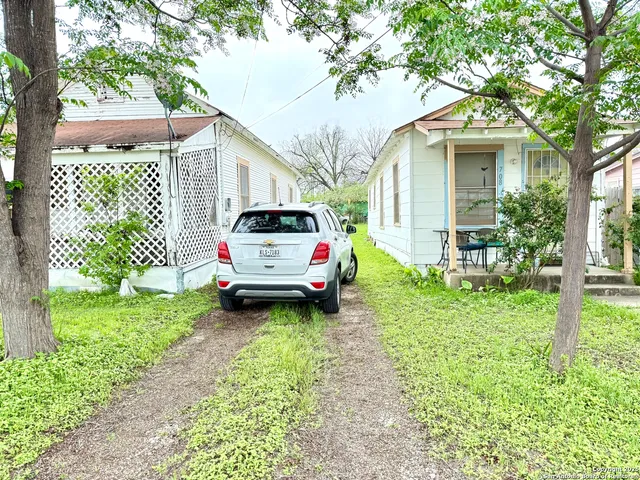 a white house with a small yard and trees