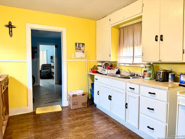 a kitchen with sink cabinets and wooden floor