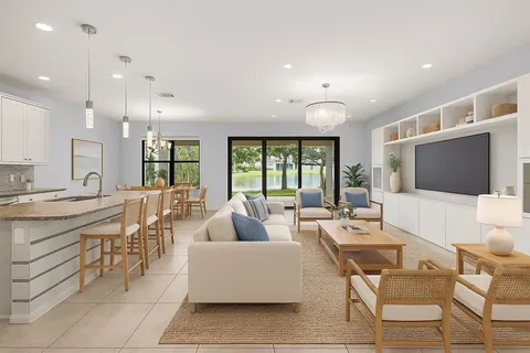 a large white kitchen with kitchen island a counter top stainless steel appliances and cabinets