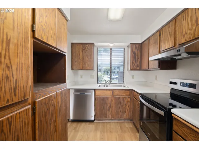 a kitchen with a sink cabinets and stainless steel appliances