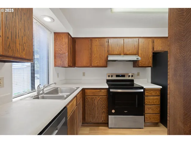 a kitchen with a refrigerator and a stove top oven