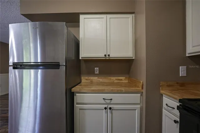 a view of kitchen with refrigerator cabinet and cabinet