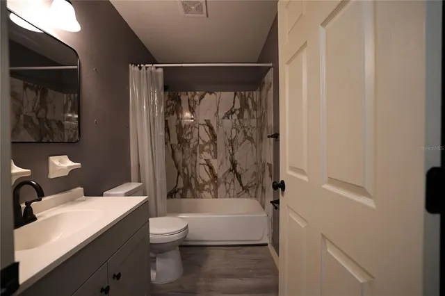 a bathroom with a sink toilet and shower