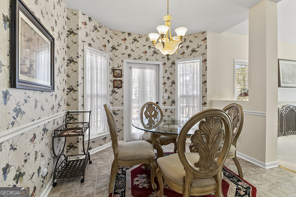 643 Millrun Court Macon, GA 31210 - Photo 17 of 32 a view of a dining room with furniture a chandelier and wooden floor